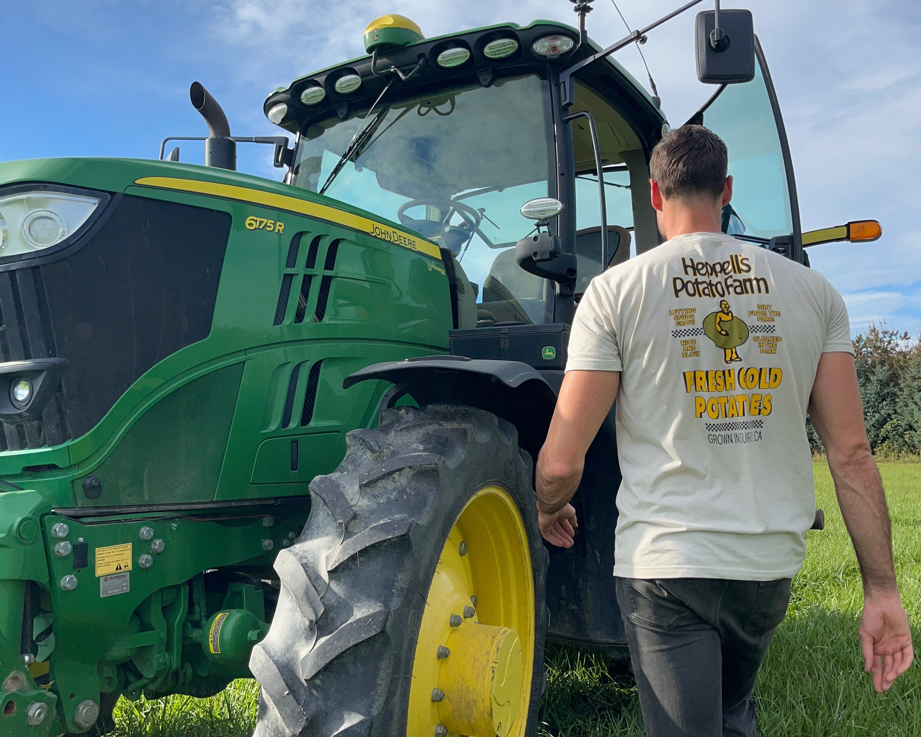 Potato Ty standing next to a green tractor at Heppell's Farm